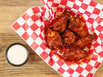 Baked chicken wings tossed in sauce with ranch at Durkin&rsquo;s Pizza